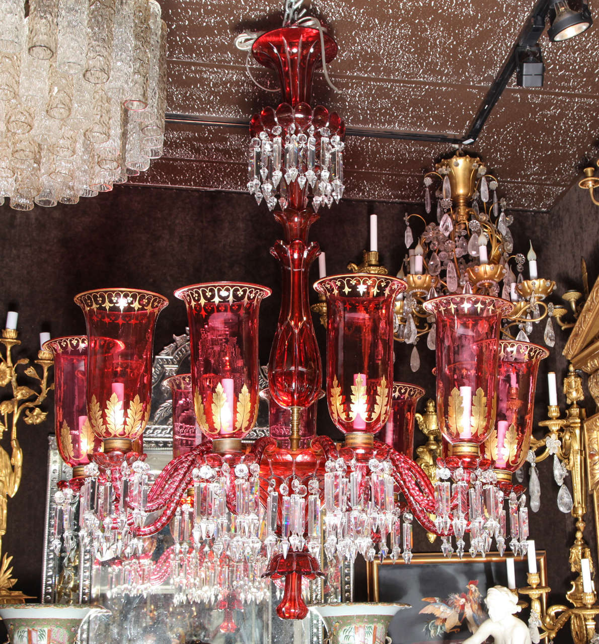 An exquisite antique Baccarat ruby red and clear crystal double overlay eleven-light chandelier with original hurricane shades. This magnificent chandelier has eleven arms that snake first down then up to the hurricane shades, which are decorated