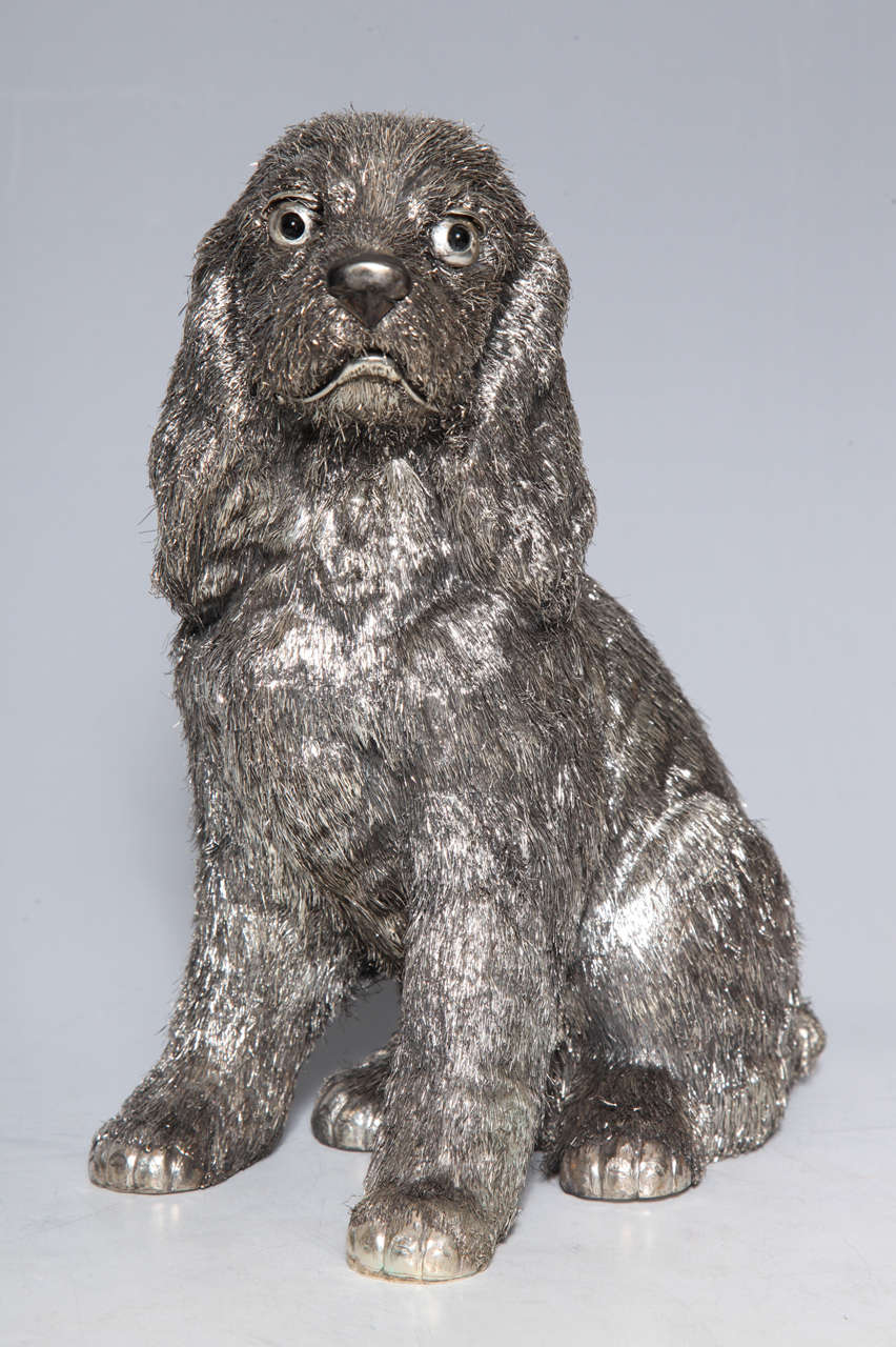A rare seated silver haired Spaniel Dog statue with black enamel eyes signed by Mario Buccellati. The silver haired dog statue is lifelike in its mannerism and gaze while its precious form gives the canine it's decorative charm. The detailing of the