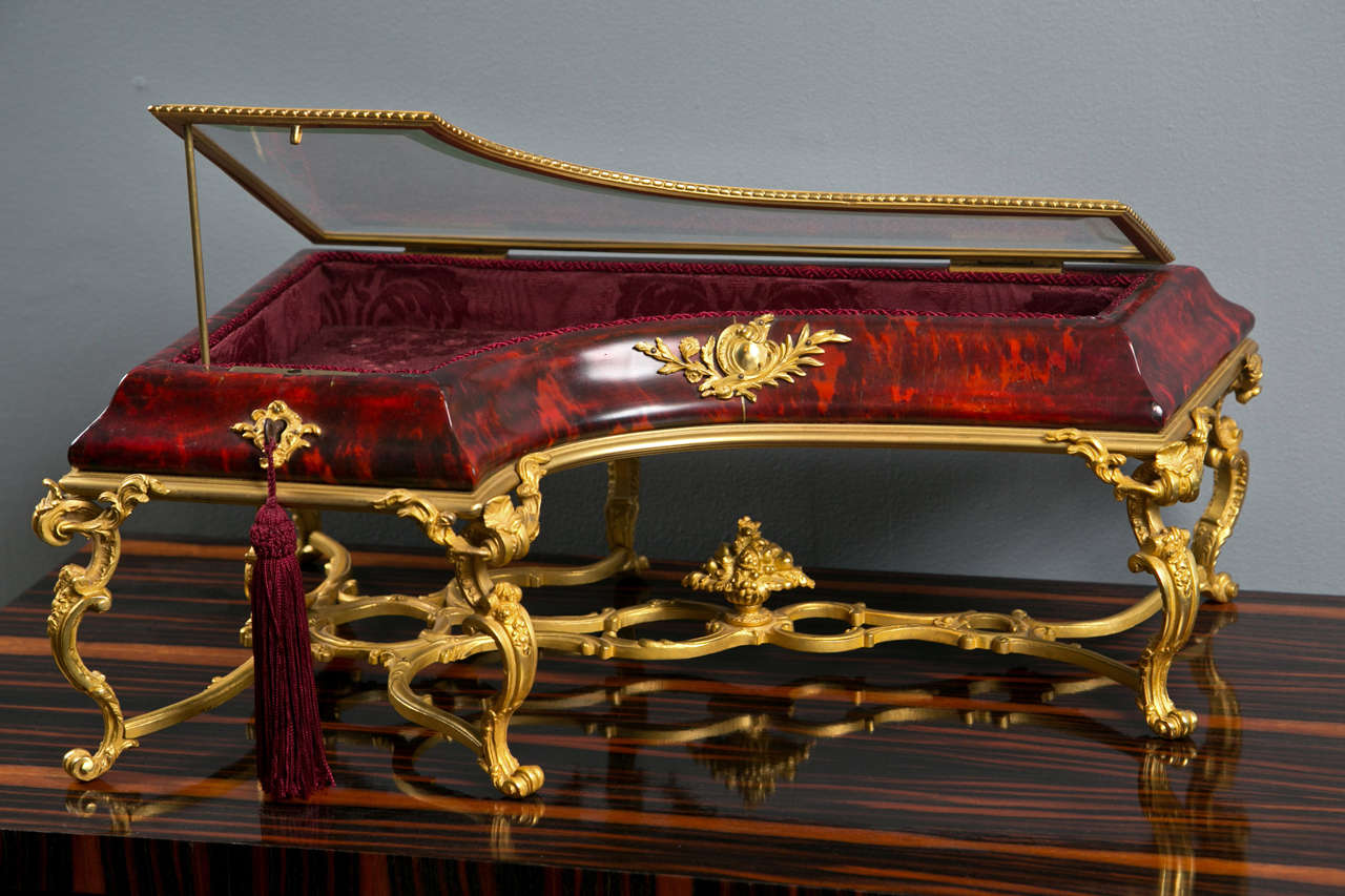A 19th century French red tortoise shell table top vitrine in the shape of a piano with gilt bronze mounts.