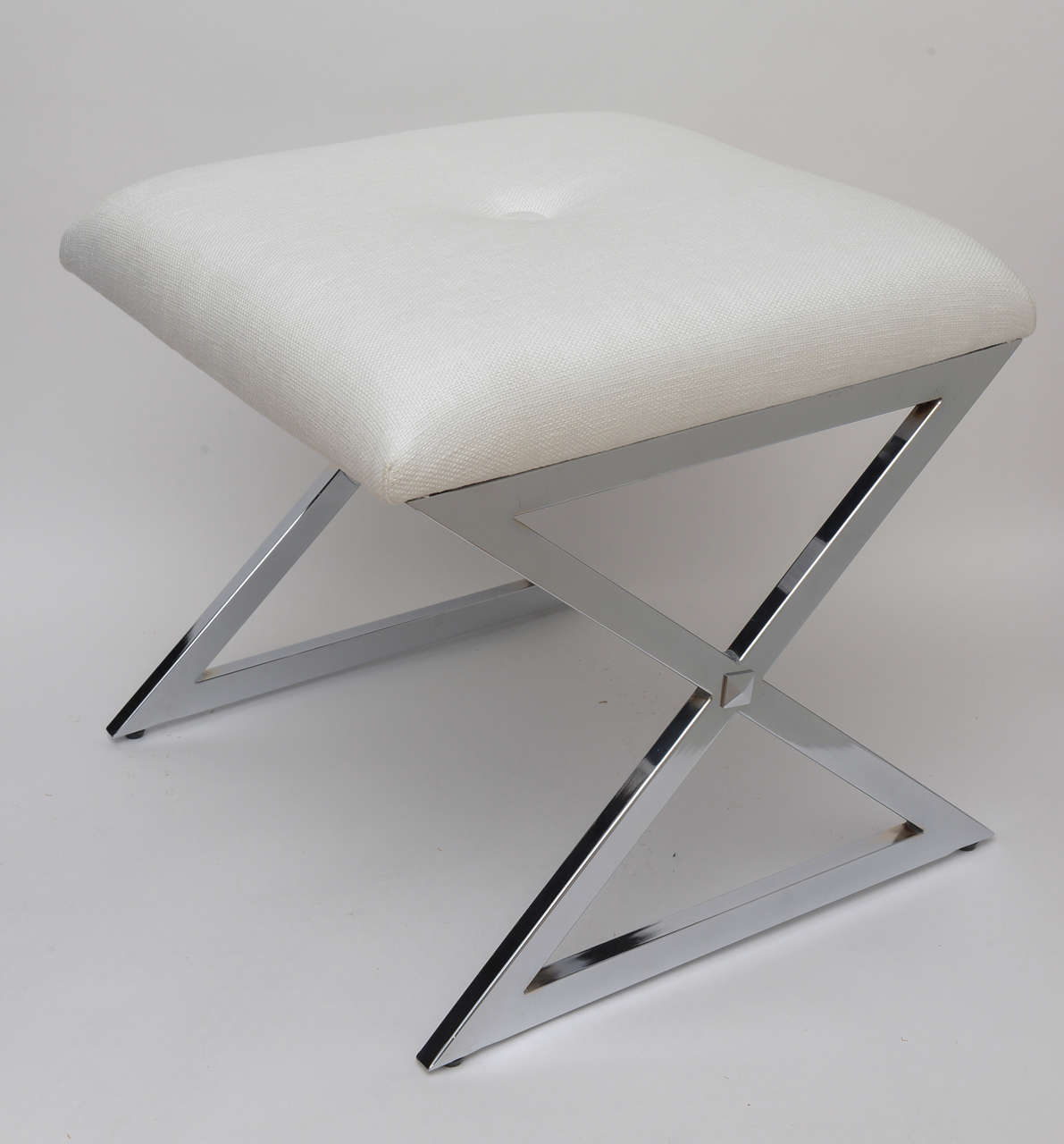Clean simple sculptural lines and newly white linen upholstery make this small bench perfect for so many places. The X and Z of the bench form different angles.It is in the style of Milo Baughman.
It has been polished and has a big button in the