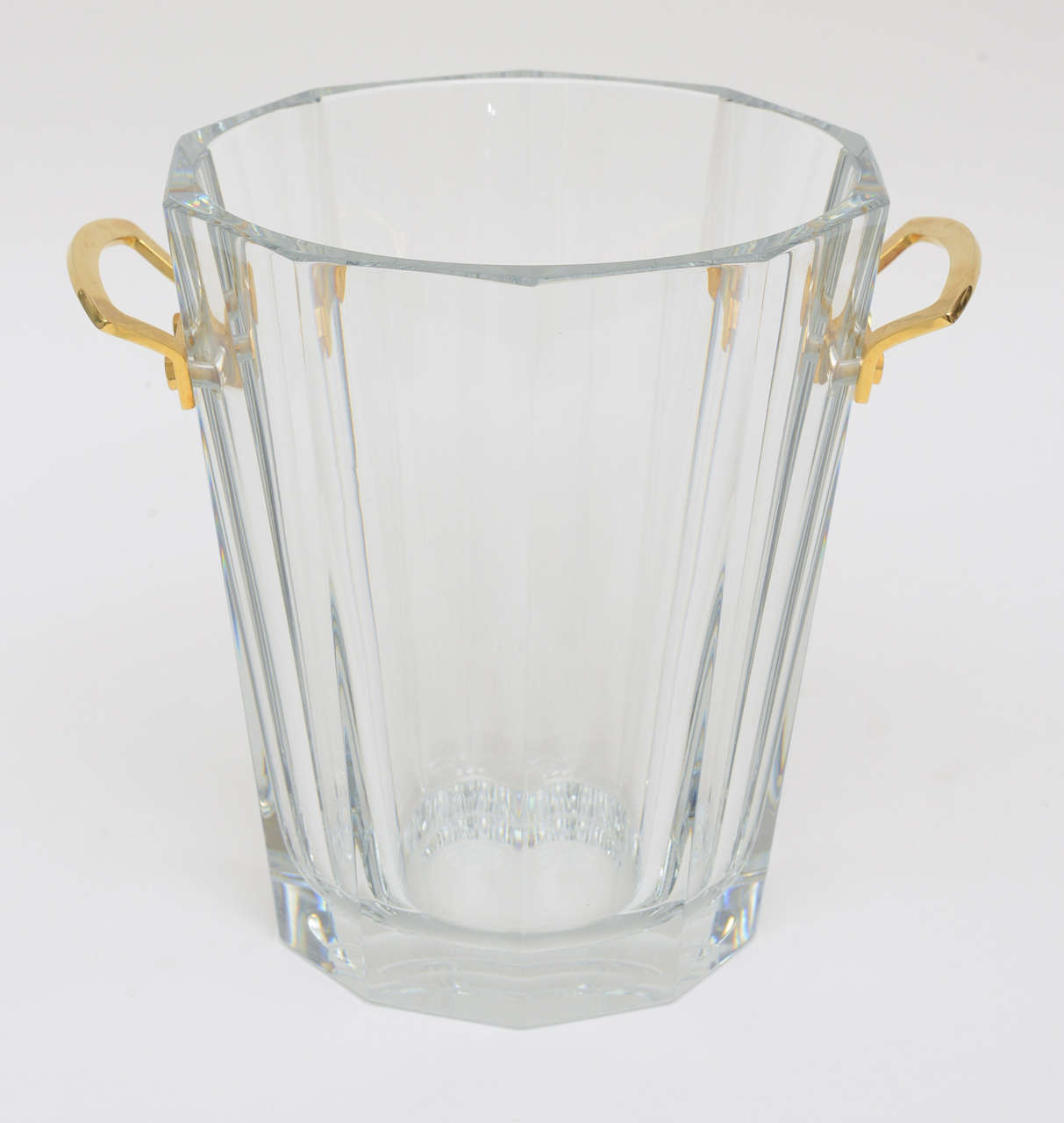 This substantial and stunning heavy large ribbed crystal signed French Baccarat champagne or ice bucket is elegant with restraint.
This particular one has long been discontinued. It is collectable.
The gilded bronze handles at either end are