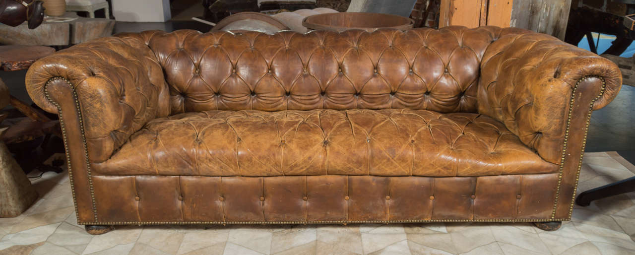 1940's French Chesterfield sofa with original leather.  Brass nail head detailing along the Arm rail and base.