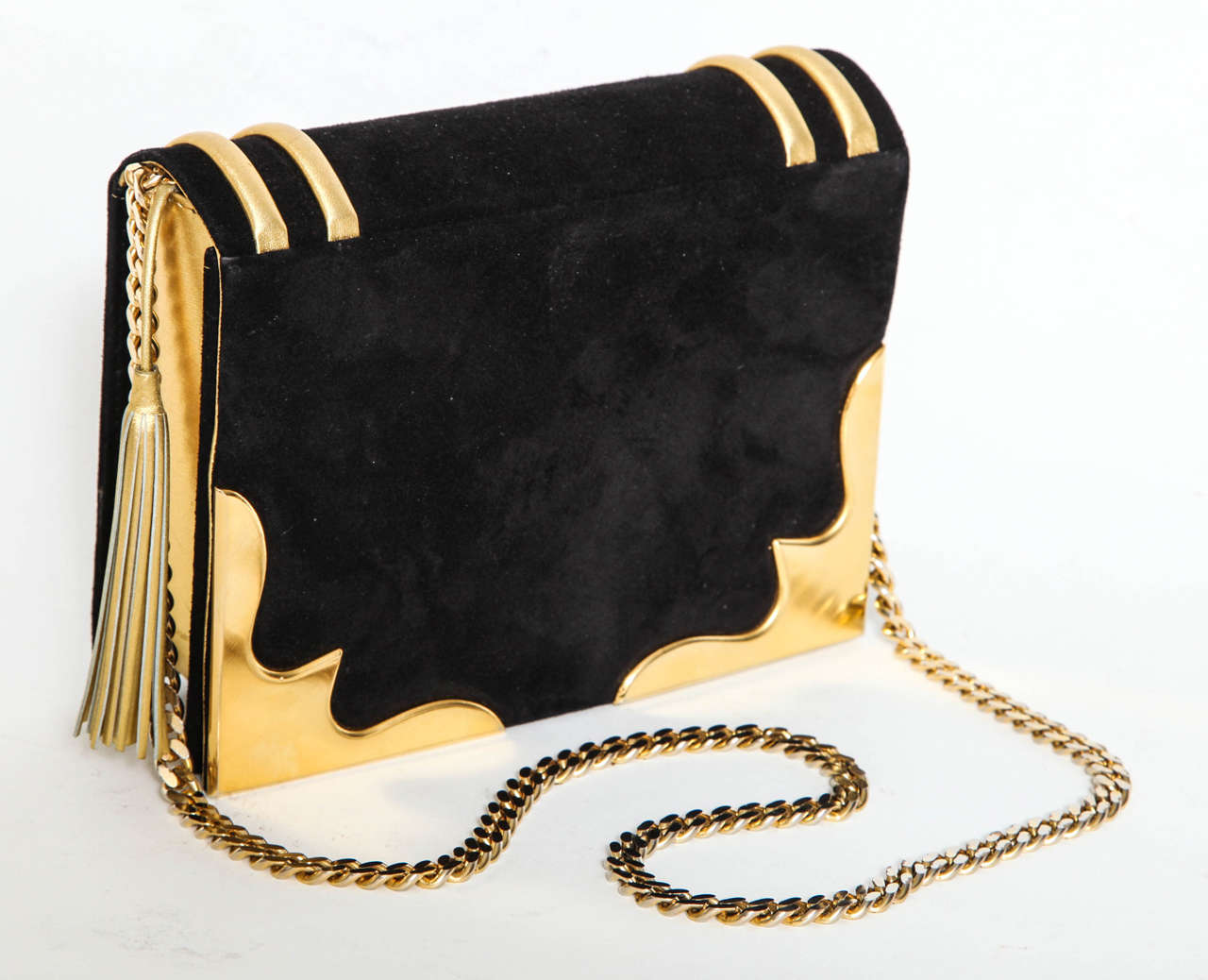 This purse is one of  Paloma Picassos's outstanding designs .  It is functional and stylish made of black suede and gold leather trim adorned with a gold leather tassel and gold chain and decorative corners.
