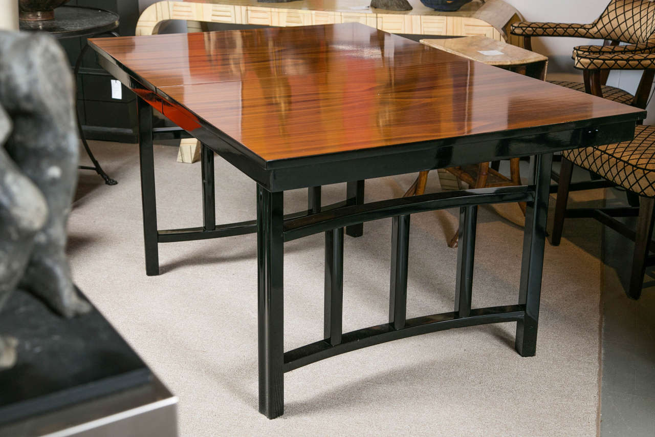 Mid-century modern lacquer and wood dining table, with two leaves.