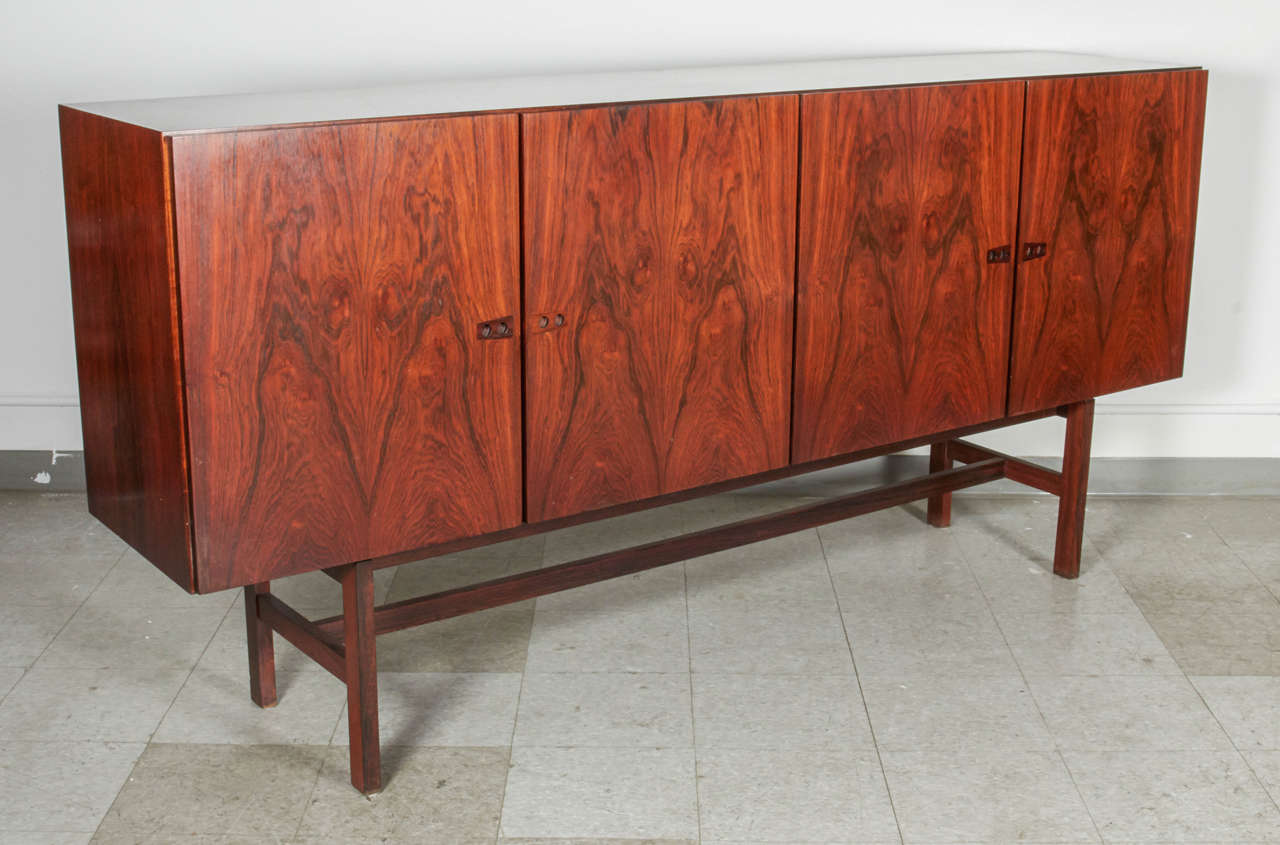 A beautiful sideboard with great detailing including unique finger pull cabinet doors. The interiors includes felt lined drawers and adjustable shelving. Attributed to Kai Kristiansen.