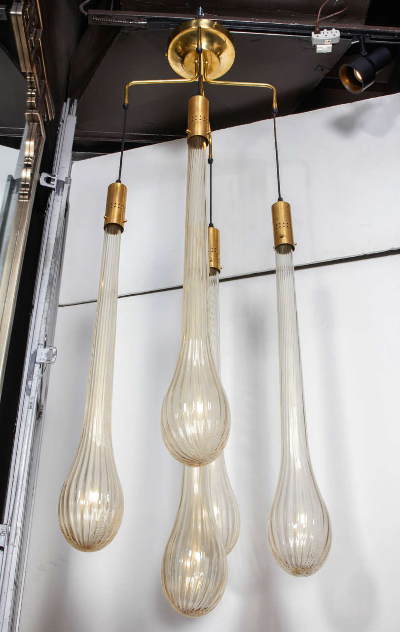 This exquisite lighting fixture is comprised of five handblown Murano glass pendants with rare long tear drop design. Additionally, the glass pendants have fluted details as well 24-karat gold flecks within the glass, creating a golden tone cast.