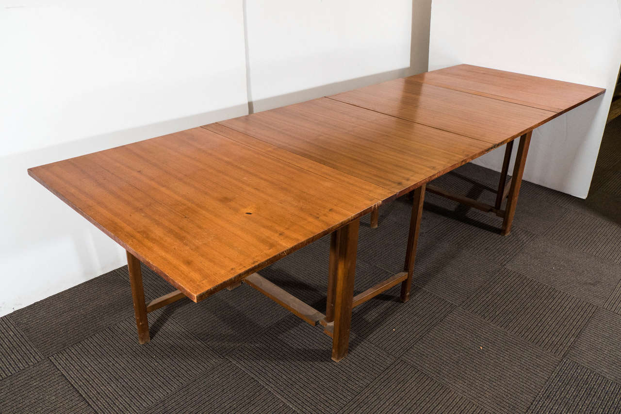 A vintage dining table, produced circa 1950s by Swedish designer Bruno Mathsson, in lacquered wood with brass hardware on versatile gatelegs, which, when folded, converts this piece into a console only 9