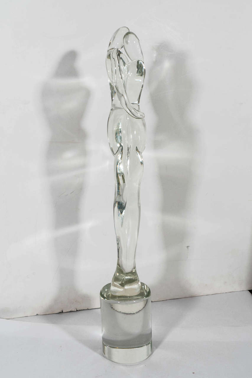 A vintage Murano glass sculpture of two stylistically Expressionist, elongated figures embracing one another, above a cylindrical base, produced circa 1960s - 1970s, in the style of Seguso. Excellent vintage condition, consistent with age and use.