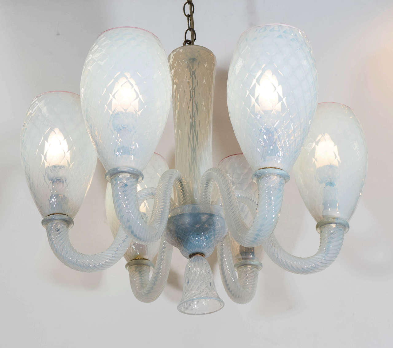 A vintage Murano glass chandelier in translucent opaline glass, with an iridescent sheen, produced circa 1960s by Barovier e Toso, with six scroll arms in twisted glass, traditional 'balloton' method applied to the bulb shades, central stem,