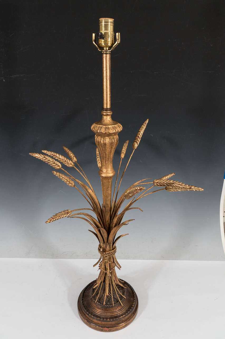A vintage gilt brass table lamp, with classically formed plaster stem surrounded by splayed wheat tole on a stylized circular base; this piece was likely inspired by Coco Chanel and Yves St. Laurent, shafts of gilded wheat a popular motif often