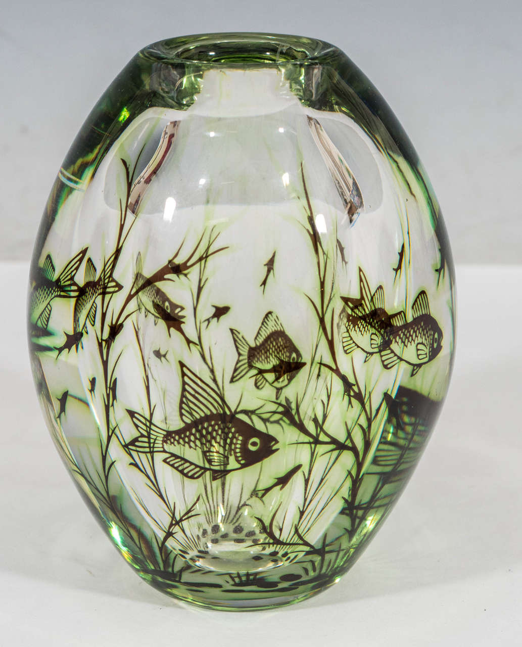 A vintage glass vase, rendered using 'graal' technique (twice-blown), with depictions of floating fish among seaweed. Produced circa 1960's by artist Edward Hald for Orrefors of Sweden. Maker's mark and artist's signature etched on bottom. Excellent