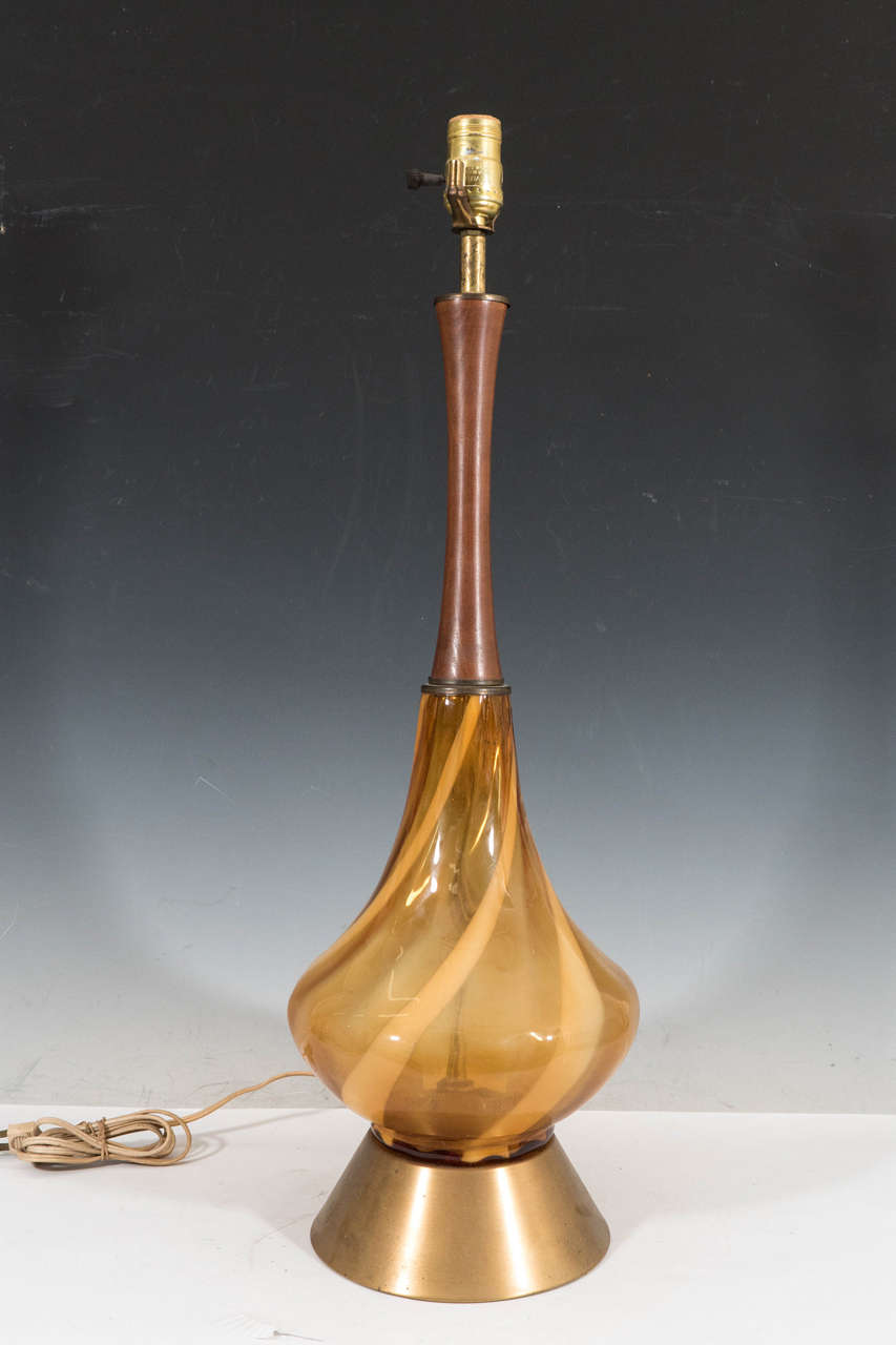 A pair of Italian glass table lamps in the modern style, with turned teak wood finials, tear-drop formed mustard yellow glass stems with "lattimo" swirl pattern, on brass cylinder bases. Wiring and sockets to US standard, each requires one