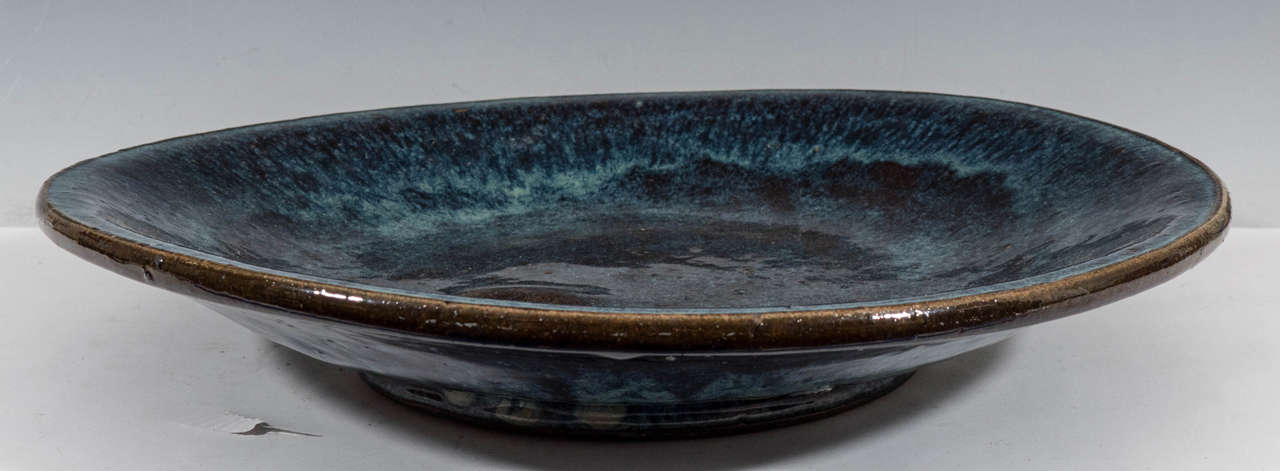 A large Japanese stoneware charger, in dark blue with glazed surface. Good condition, with some minor scratches to surface.