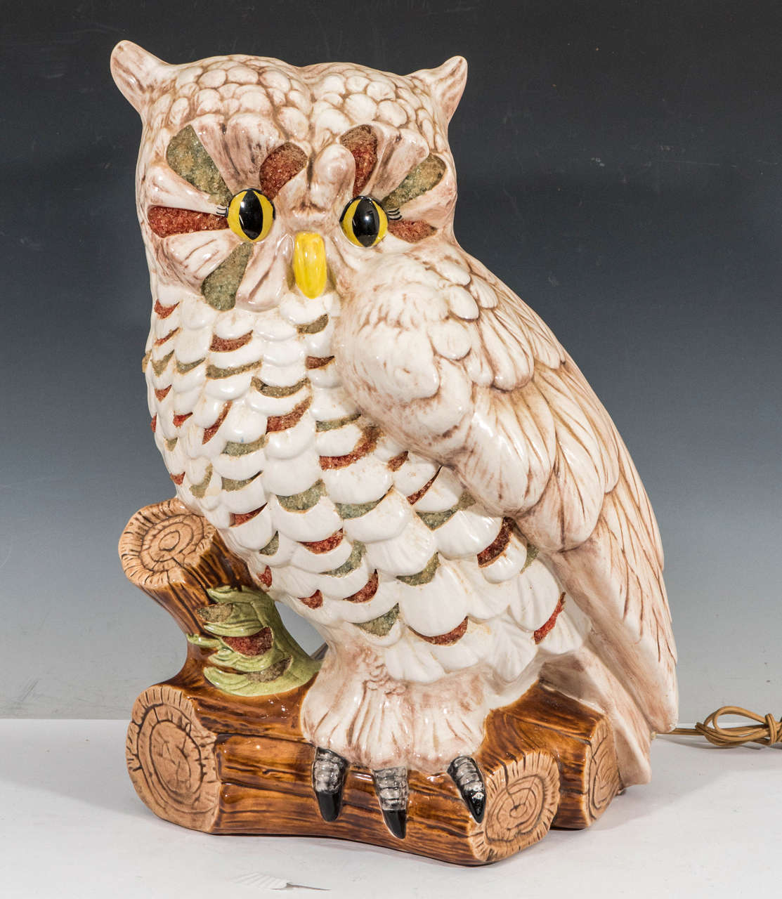 A vintage painted and glazed ceramic lamp, in the form of a highly detailed and colorfully painted owl perched on a log. Whimsical design and illuminating eyes are reminiscent of TV lamps produced circa 1950's by Texans Incorporated. Wiring and
