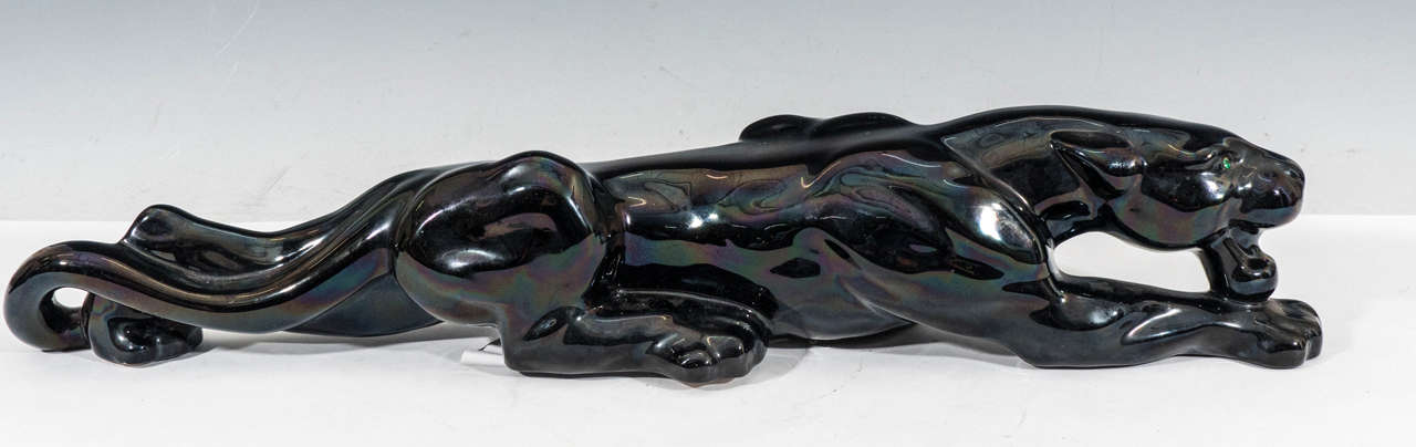 A vintage art deco style ceramic black panther stalking, with iridescent sheen and green rhinestone eyes. Produced circa 1950's by Royal Haeger, based on 1941 designs by Royal Hickman. Excellent vintage condition, with some scuffing to the bottom,