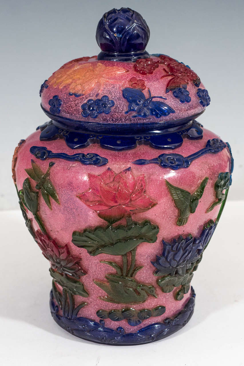 A Chinese cut-glass peking ginger jar, produced circa 1890s, within the later part of the Qing dynasty period (1644-1912), including top with indigo artichoke finial and border, the body decorated with flora and fauna motifs, including flowers,