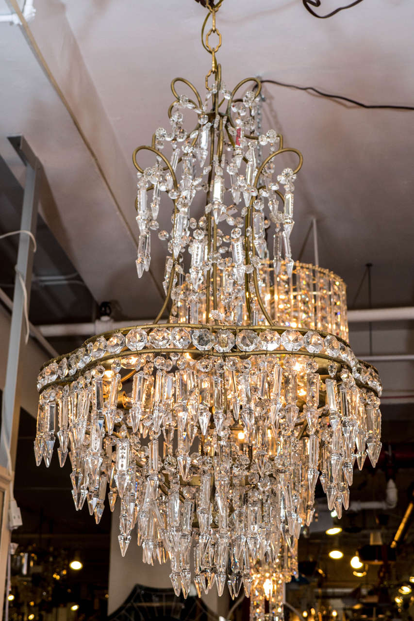 An Italian circa 1950s chandelier, with scrolling gold-plated frame and trimmed with Swarovski cut crystal drops. Newly rewired to US standard, requires 12 bulbs. Good vintage condition, with minimal age appropriate patina.