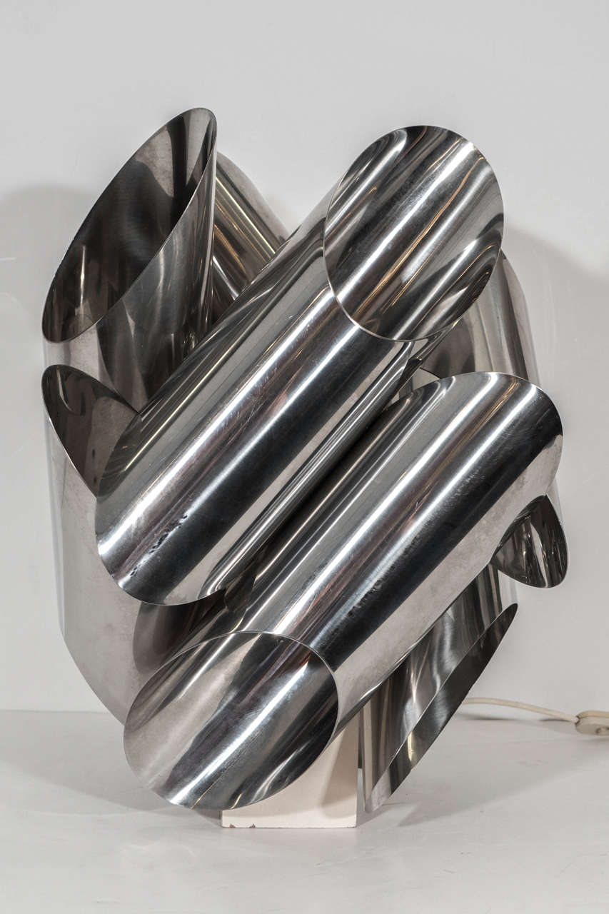 A sculptural table lamp by Italian designer Gaetano Sciolari, created 1970s, with cylindrical cut, treated chrome tubes surrounding the socket and rectangular base. Wiring and socket to US standard, requires one Edison base bulb.