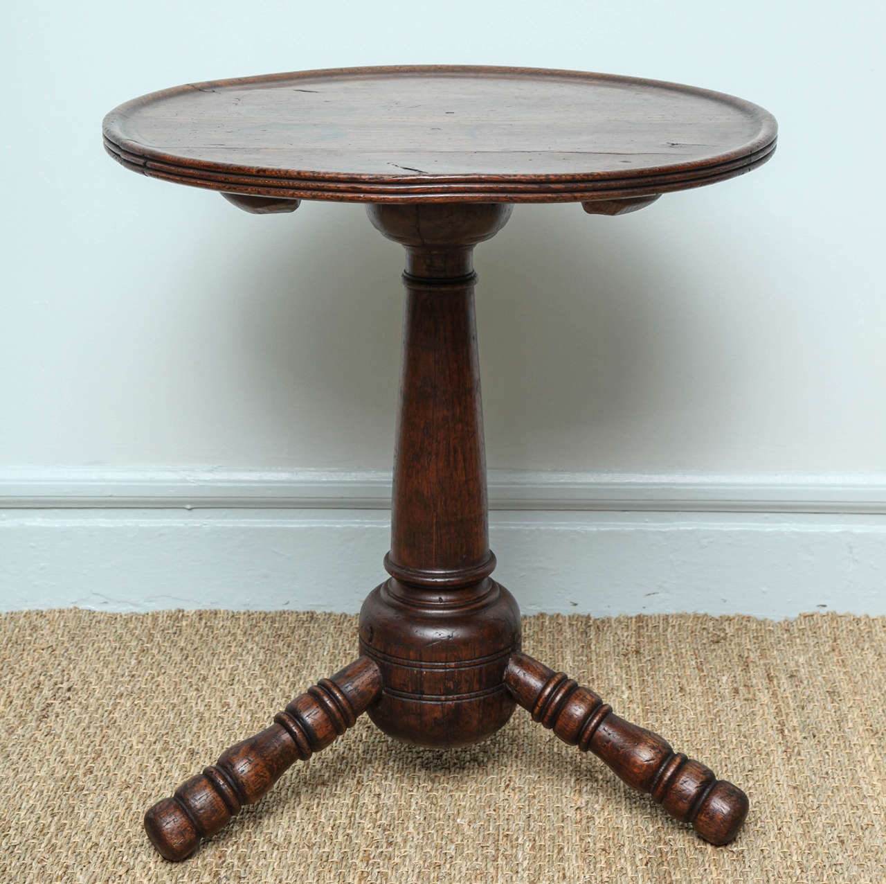 Rare English or Welsh oak turner's table, the two board dished top with reeded edge, the cannon barrel turned leg ending in bulbous bottom and the three socketed turned legs with vase and ring decoration, the whole with pleasing color. Sometimes