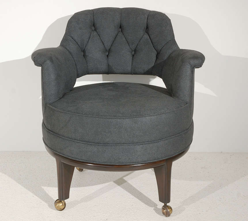 A distinctive set of four tub chairs with walnut legs on brass casters with gently rolled arms and diamond-tufted backs. Perfect for use at a game table. Newly reupholstered in a charcoal microsuede.