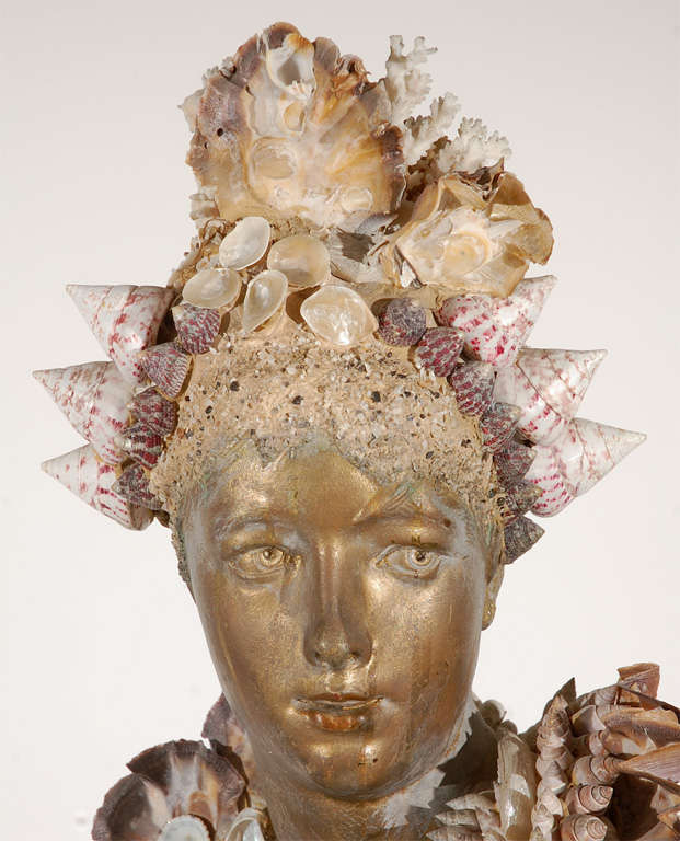 A fanciful grotto style cast plaster bust painted in a metallic gold and embellished with a variety of seashells and Amethyst crystals.