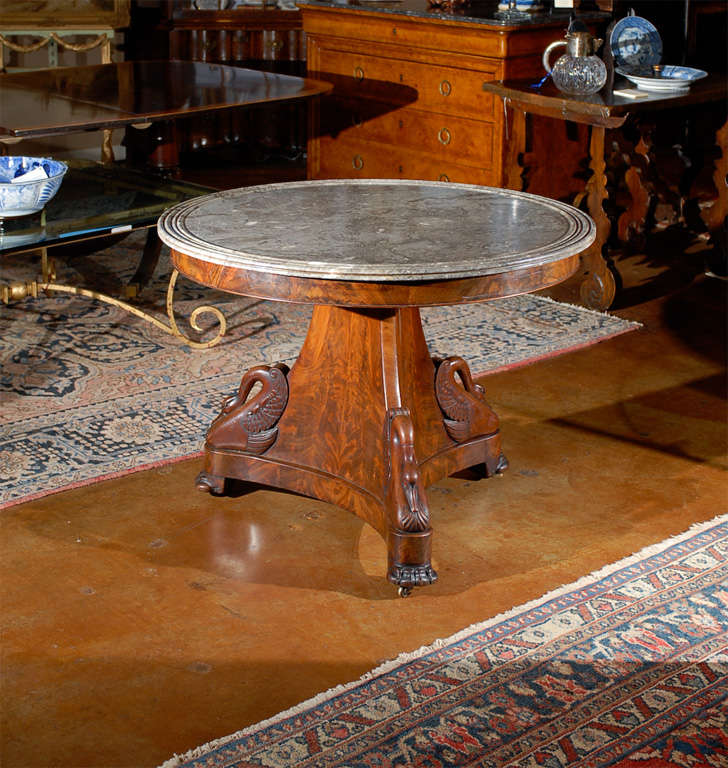 Hand carved flame mahogany Empire table with original grey marble top.
