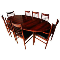 A Rosewood dinning table with 8 chairs by Arne Vodder.