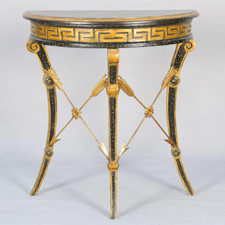 Demilune console table, in Neoclassical taste, painted and parcel gilt, it's semi-circular molded top on apron out-carved with Greek key, raised on three scroll-headed sabre legs, joined by crossed arrow stretchers of gilded iron.