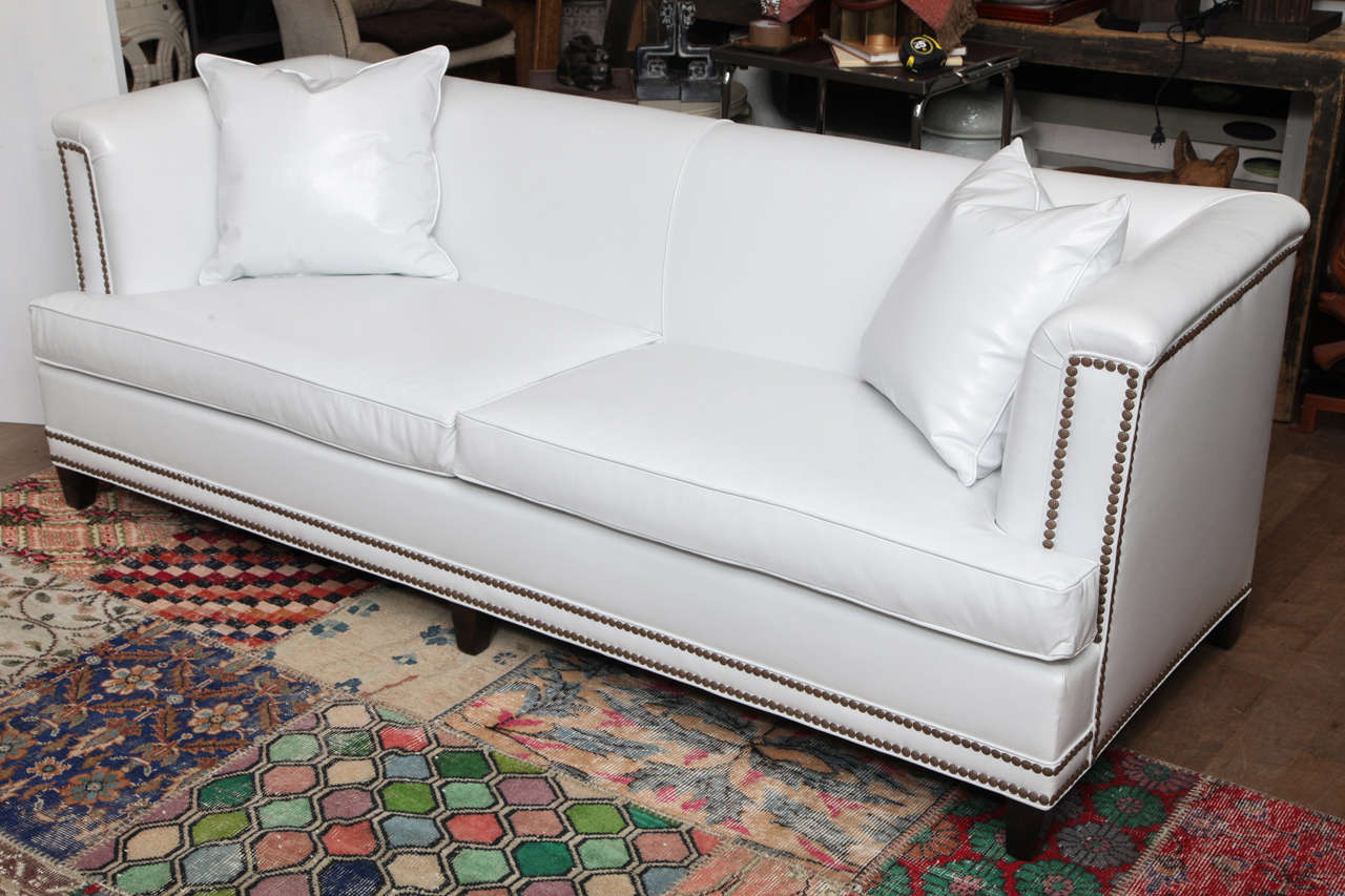 Artic white Italian leather sofa, with a modernized Chesterfield-style silhouette in the manner of Billy Haines with French natural brass nailheads circa 1950