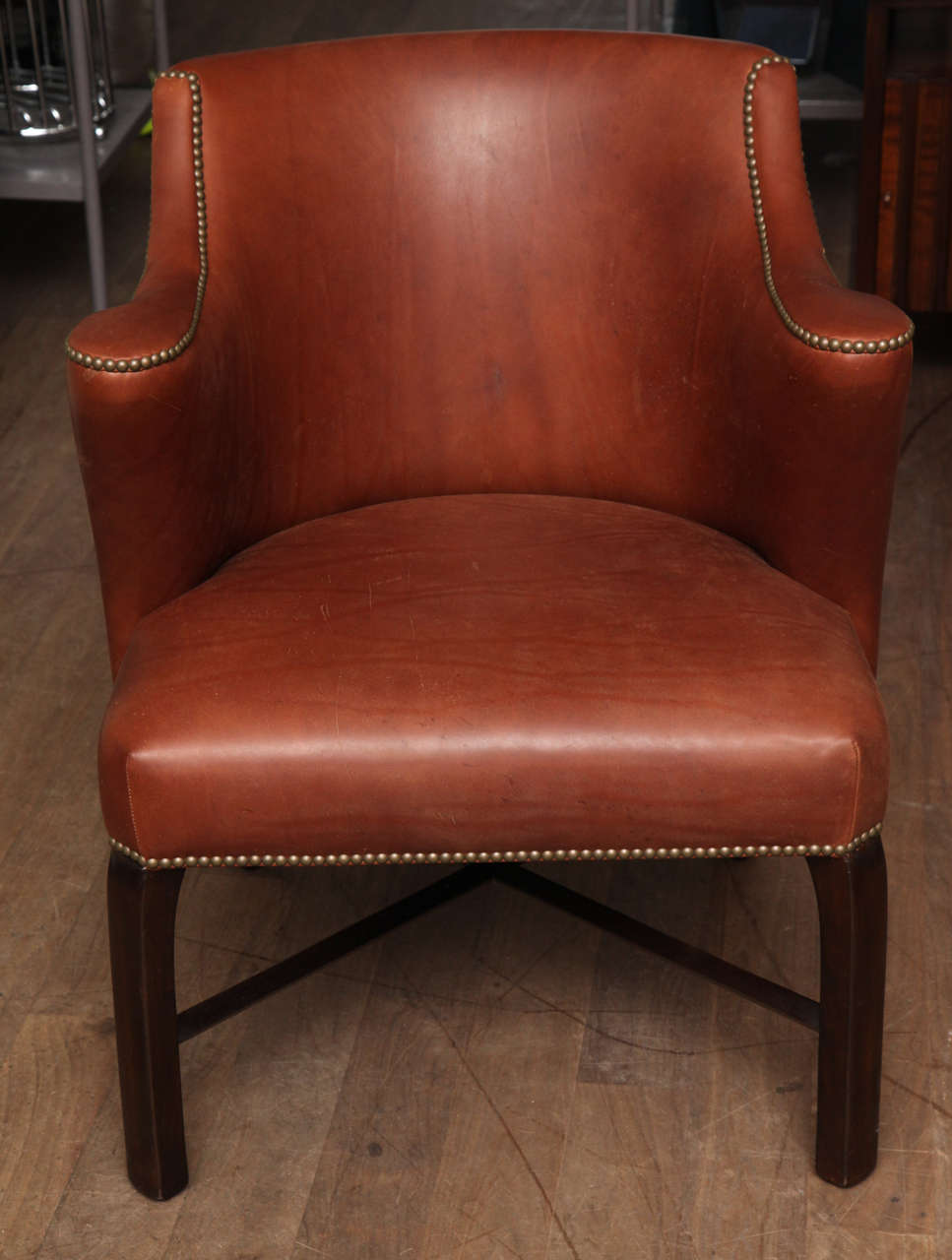 Chestnut leather barrel back armchairs with dark walnut stained stretcher bases and backed in Academy Weave in Military Green, a French twill by Thomas O'Brien for Lee Jofa circa 1950; French natural brass nailheads; Two pairs are available.