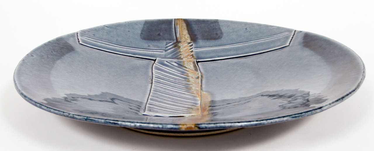 Handcrafted post modern Japanese Art studio, very nice large American ceramic pottery blue charger.
Very interesting platter with a graphic abstract relief pattern glazed with amazing shades of blue feature a line crossing the plate in light bronze