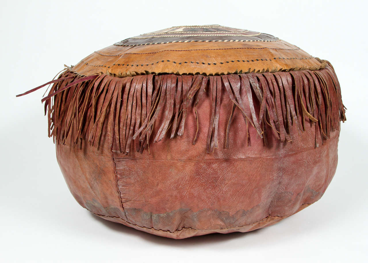AfricanTribal leather pouf. Distressed leather with geometrical handwoven leather in tribal designs, fringes all around.
Mosaik provides Antiques in Moorish style, Spanish, African Tribal Art, Islamic Art, Arabian style furniture, Middle Eastern,