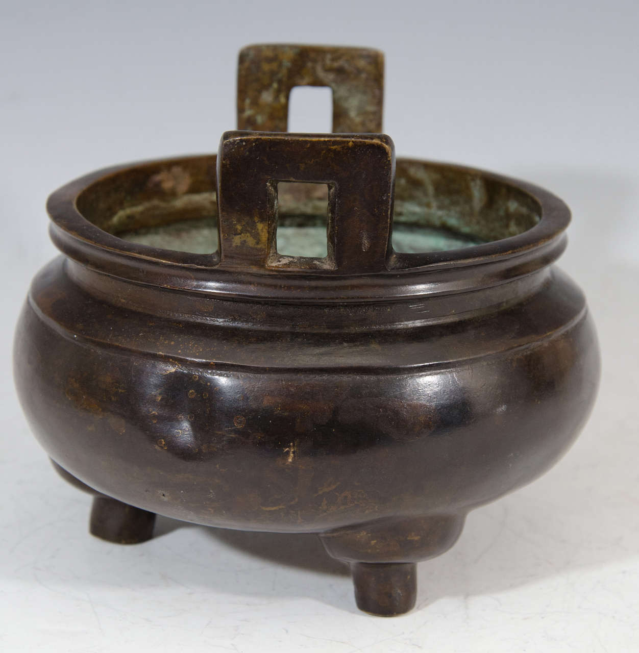 A Qing Dynasty heavy Chinese bronze incense burner with double handles, three feet, and a dark patina. The base is cast with a 16 character donation inscription for the 5th year of the Xuande Emperor (1426-1435), or 1430.

Good condition with age