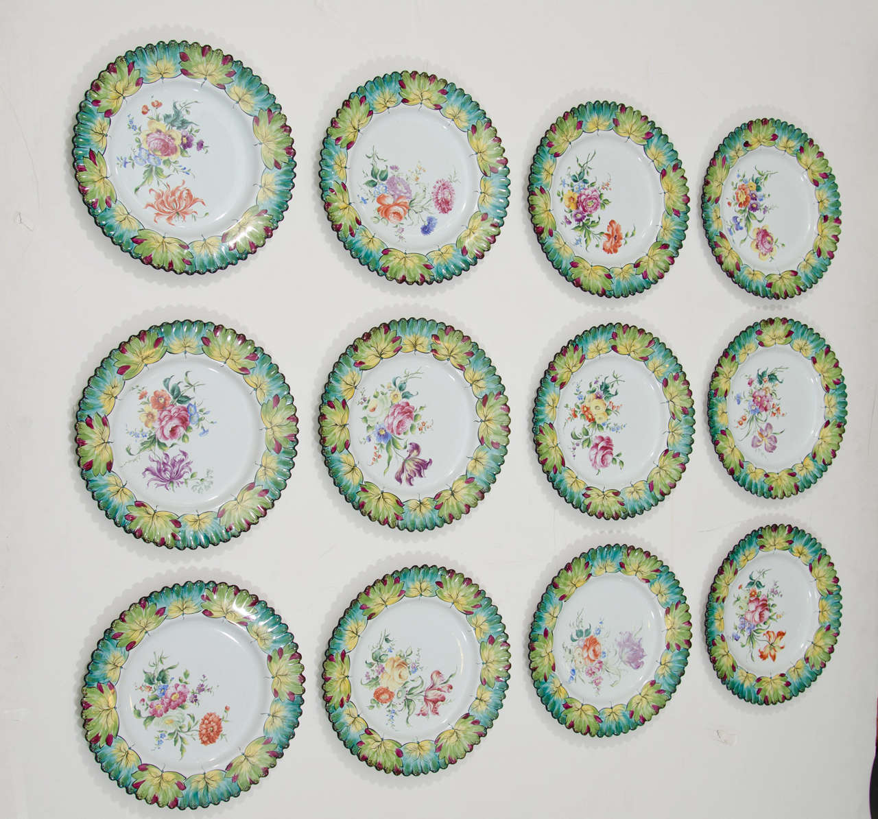 Un ensemble vintage de douze rares assiettes peintes à la main avec des bords festonnés par Camille Le Tallec pour Tiffany & By. Fabriquée en 1964, et peinte par un artisan portant les initiales G.M.

Dix plaques sont en parfait état.  L'une des