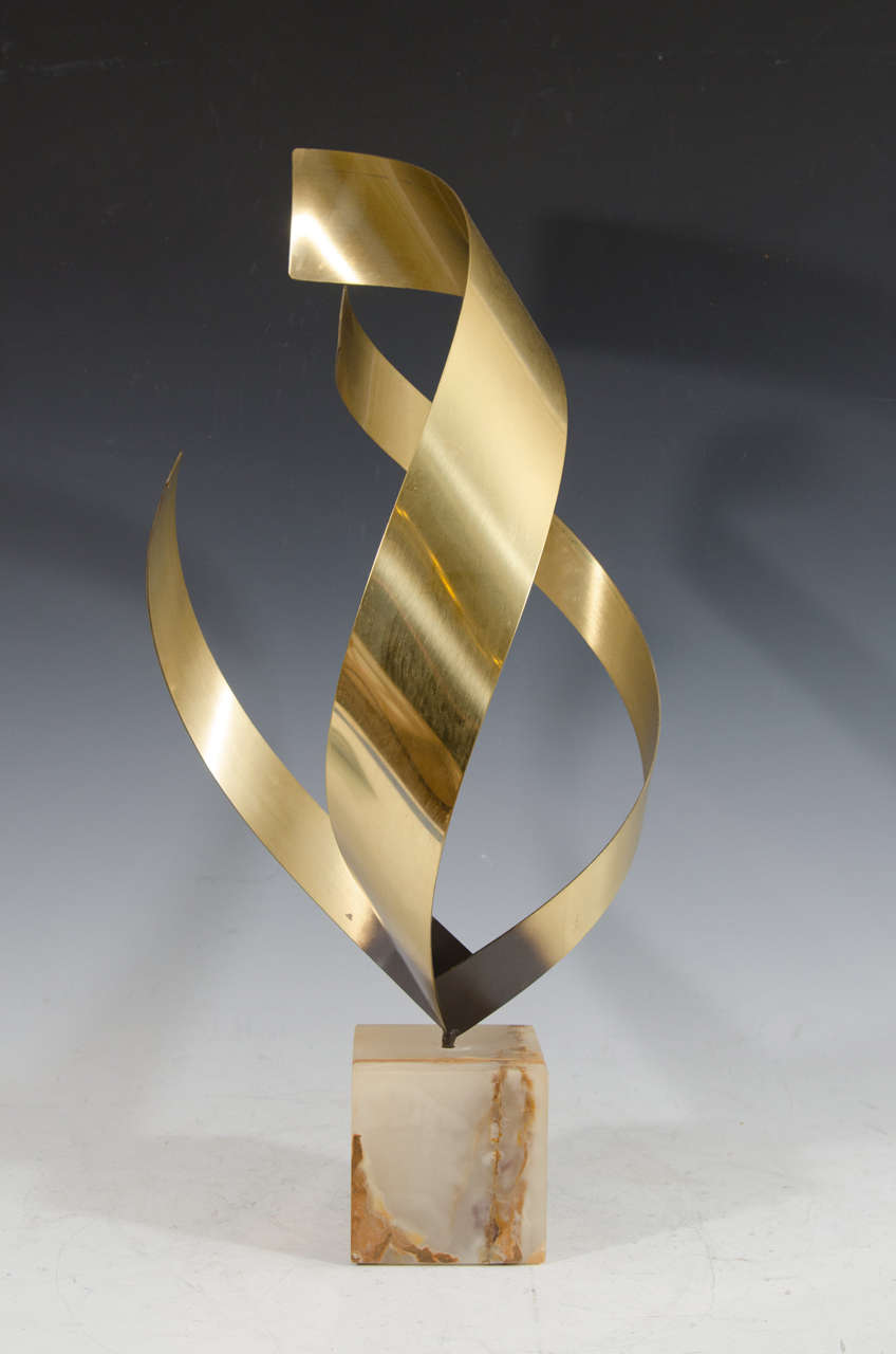 A vintage Curtis Jere brass sculpture of an abstract flame, on a 4