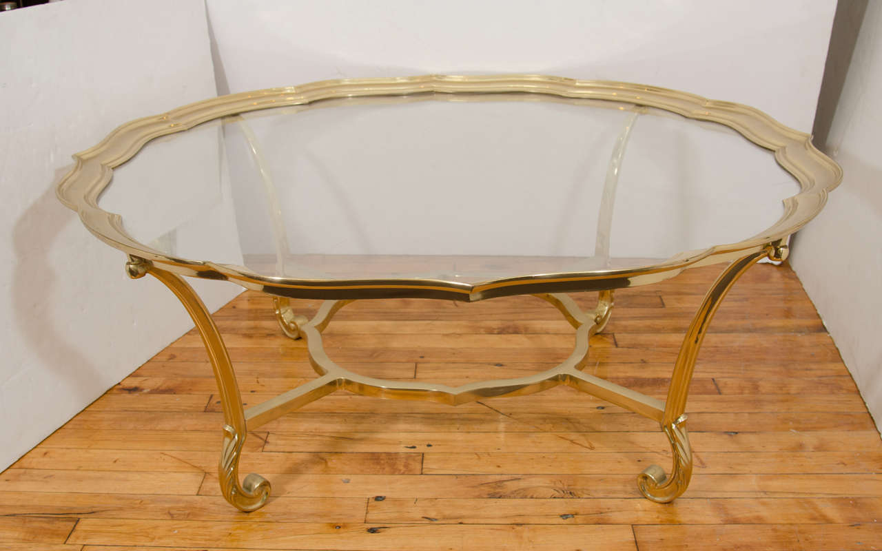 A vintage Italian glass top inset in a brass table base with scalloped edges.

Good vintage condition with age appropriate wear.