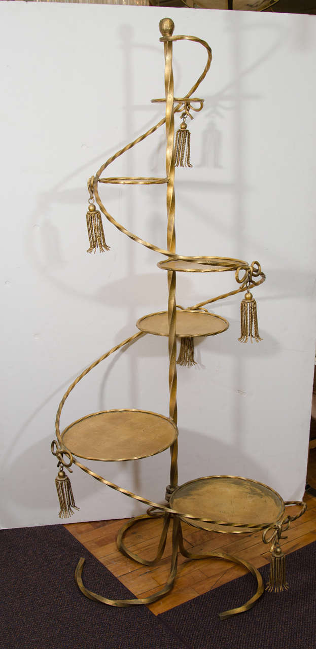 A mid century 1950's spiral plant stand with tassel ornaments and round graduating platforms made of gilt finish over metal.

Good vintage condition with age appropriate wear.

Reduced from: $1,850