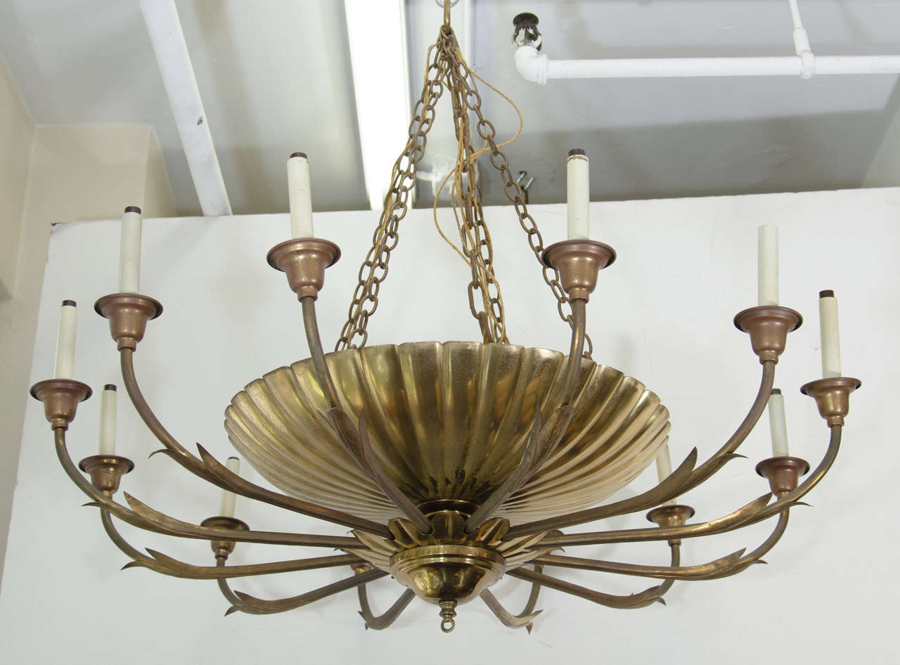A Hollywood Regency solid polished brass chandelier with twelve lights from the Harvard Business School, circa 1940s.Rewiring is necessary as this wiring is original to date of this chandelier.

Two chandeliers are available for purchase