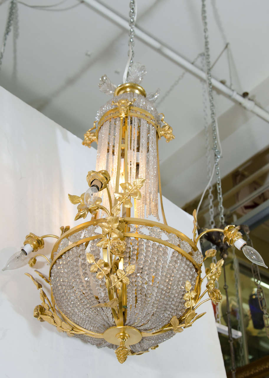 A 19th century twelve light French chandelier with crystal beaded strands on a gilt bronze frame with leaf detail.<br />
<br />
Good condition with age appropriate wear.