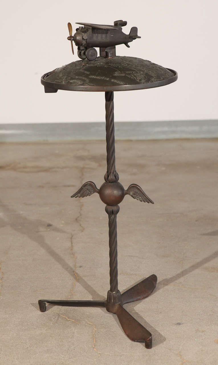 Cast metal aeronautical smoking stand topped with a model of a plane with spinning propeller.
