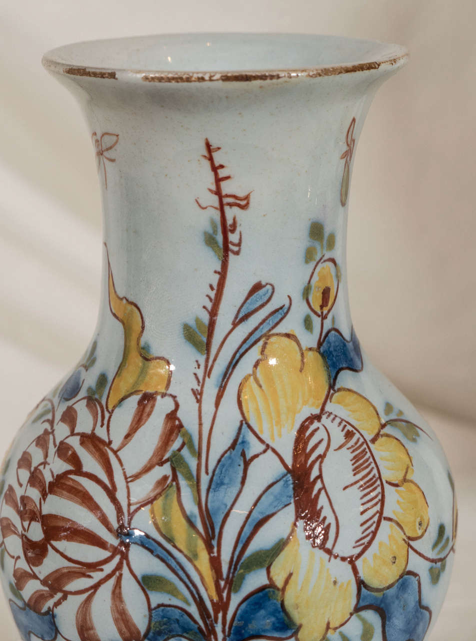 A rare small English mid-18th century delftware vase probably Lambeth or Bristol, painted in a polychrome palette of iron red, cobalt blue, green and yellow. Decorated with loose brushwork and abstract rather than naturalistic flowers.