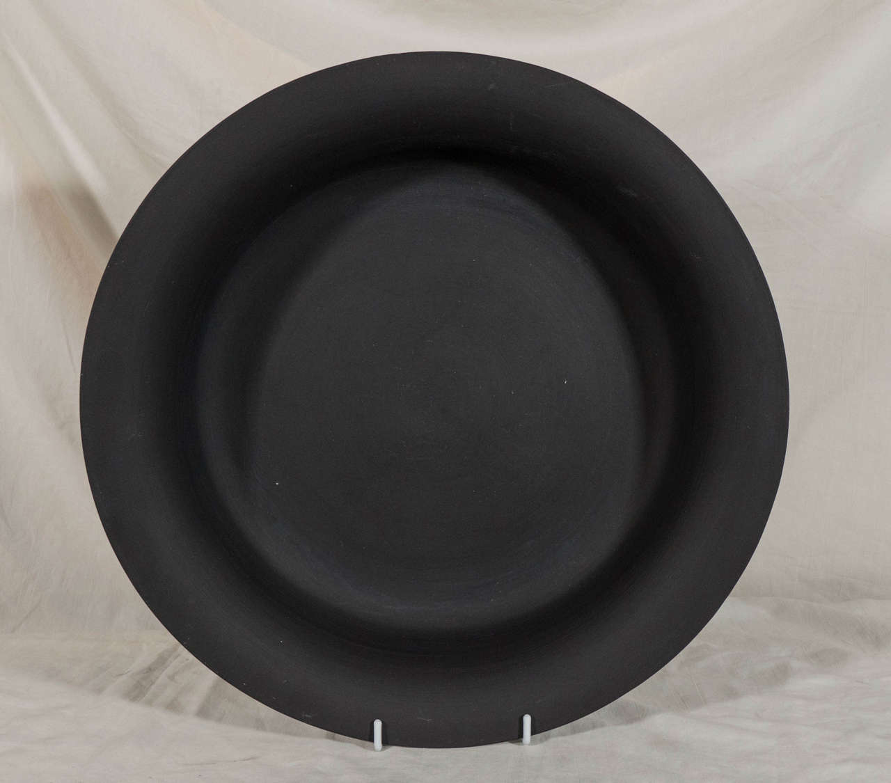 A large Wedgwood Black Basalt bowl with a low open form and simple everted lip.
Black Basalt was created by Josiah Wedgwood in the 18th century. Wedgwood transformed Egyptian Black, a traditional Staffordshire stoneware, into Black Basalt. Before