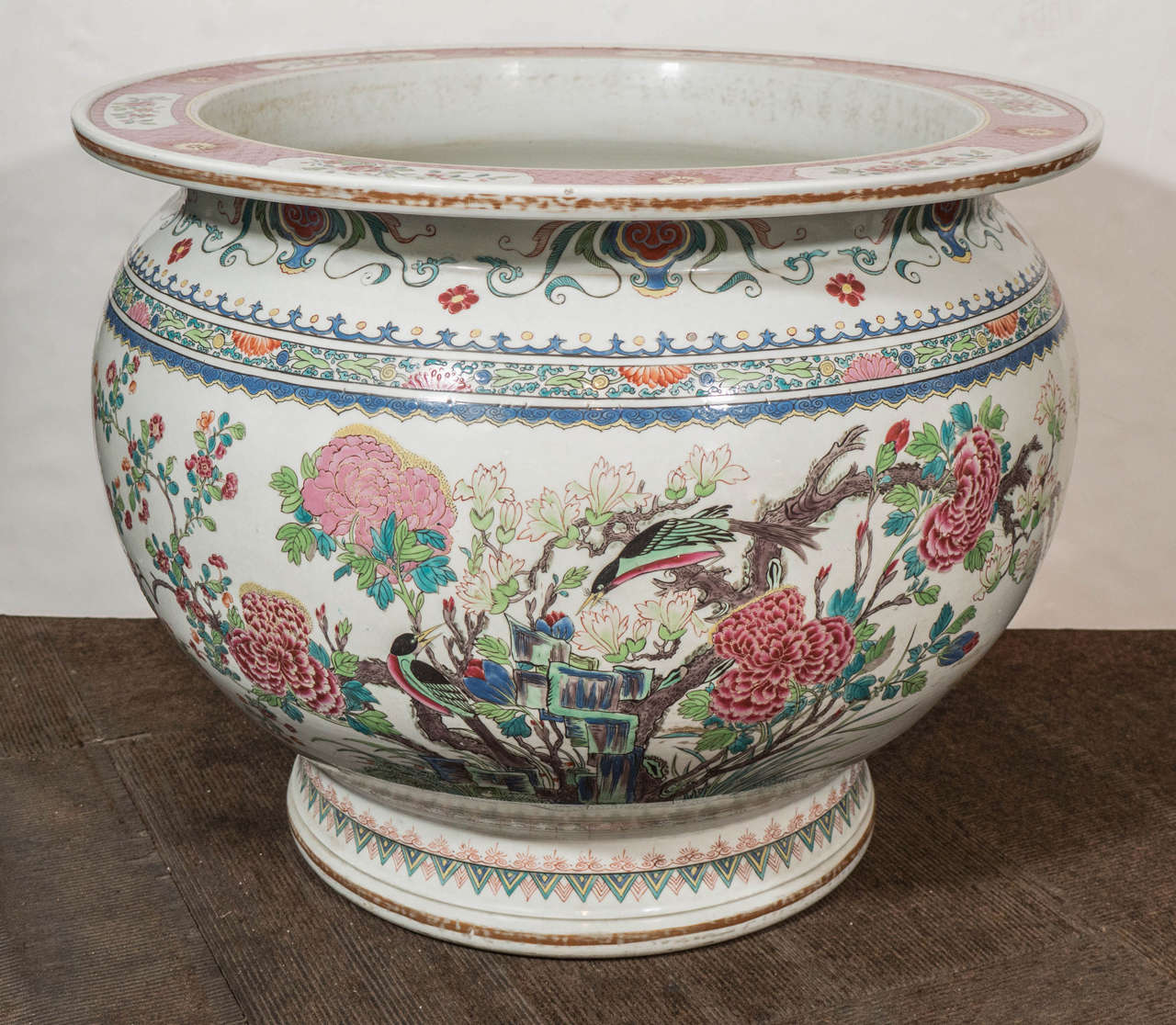 Well painted all around in bright Famille Rose enamels showing a pair of songbirds among blossoming flowers and rock work. On the reverse another pair of birds among chrysanthemums and other blooms.
The interior decorated with Chinese goldfish