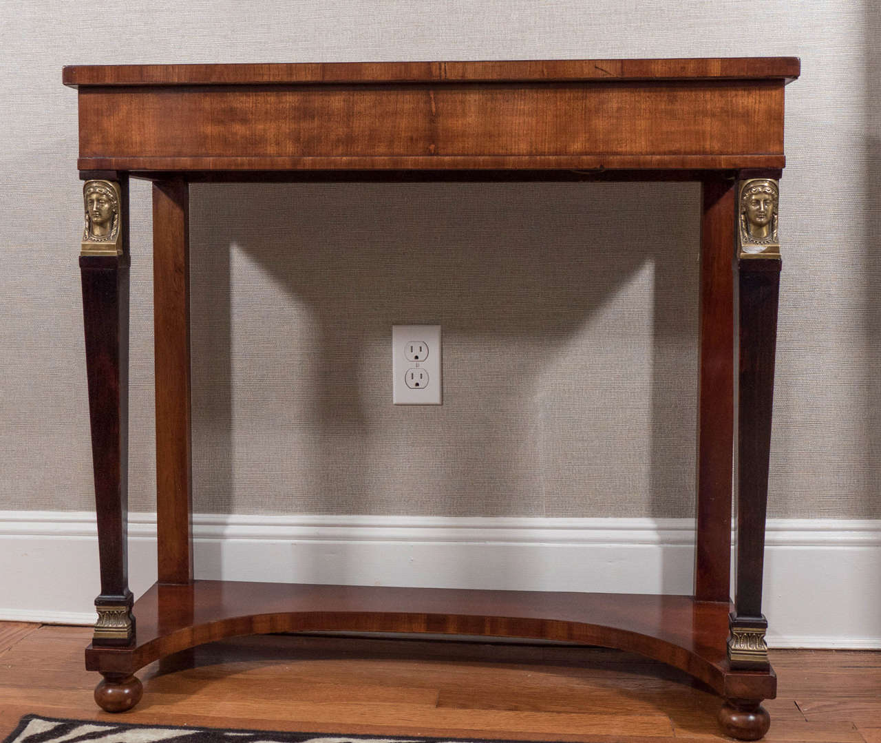 A nice looking mahogany console in a useful size, with ebonized front legs adorned with brass neoclassical figures.
