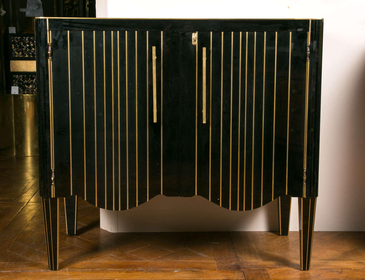 Pair of black mirror and brass fillet cabinets, two doors, shelves inside.