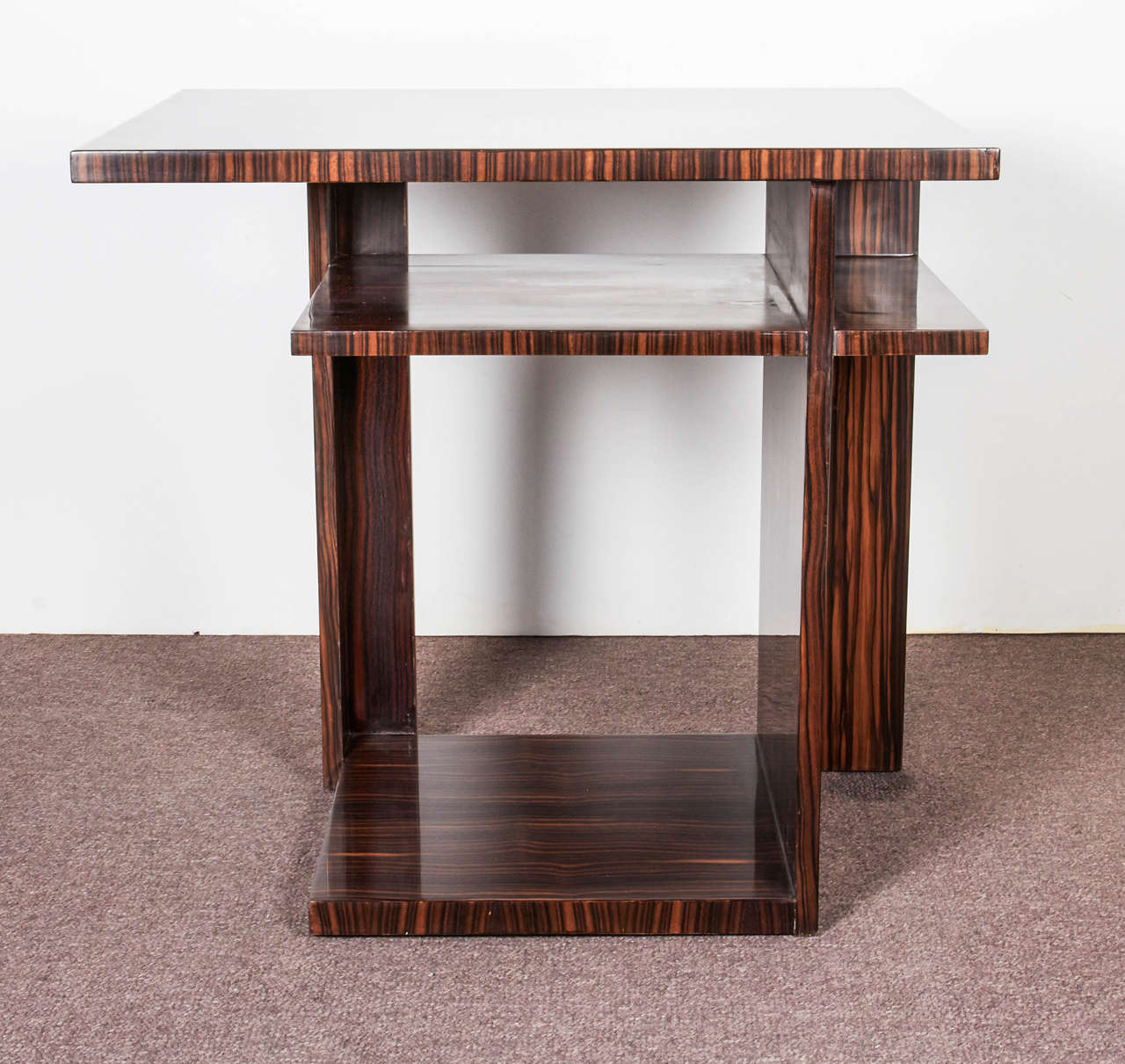 French Art Deco highly sculptural and artistic side table featuring varied levels of shelving in a striking display of asymmetrical design. This Minimalist table in exotic Macassar ebony can be used anywhere a dramatic statement is
