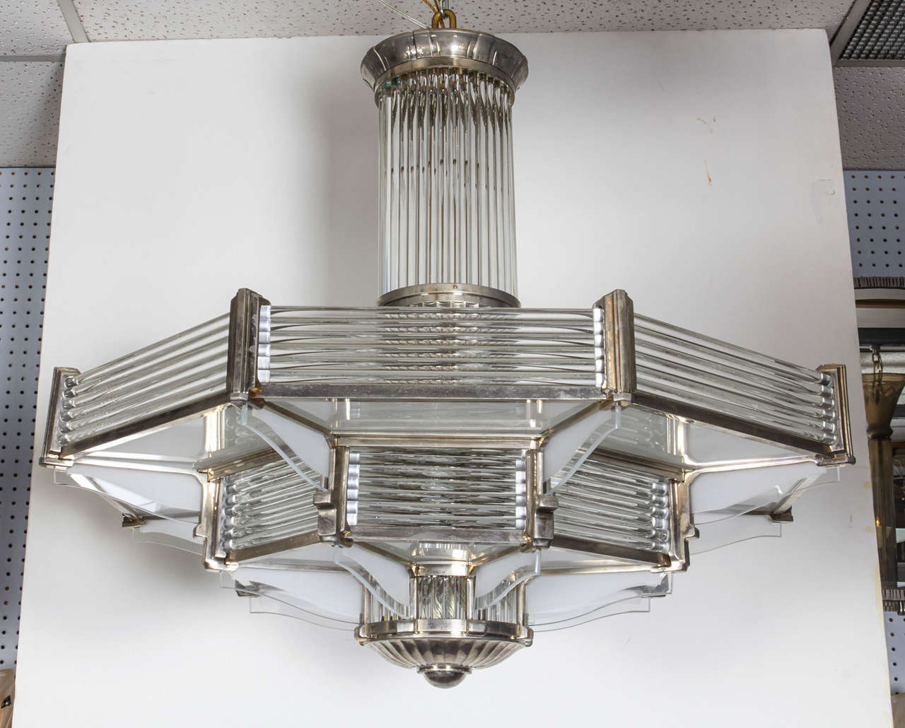 Massive French two-tier octagonally shaped chandelier by Petitot.
Horizontal glass rods, flat frosted glass insets and frosted and polished winged panels are set into a highly polished nickeled bronze armature. The vertical support features an