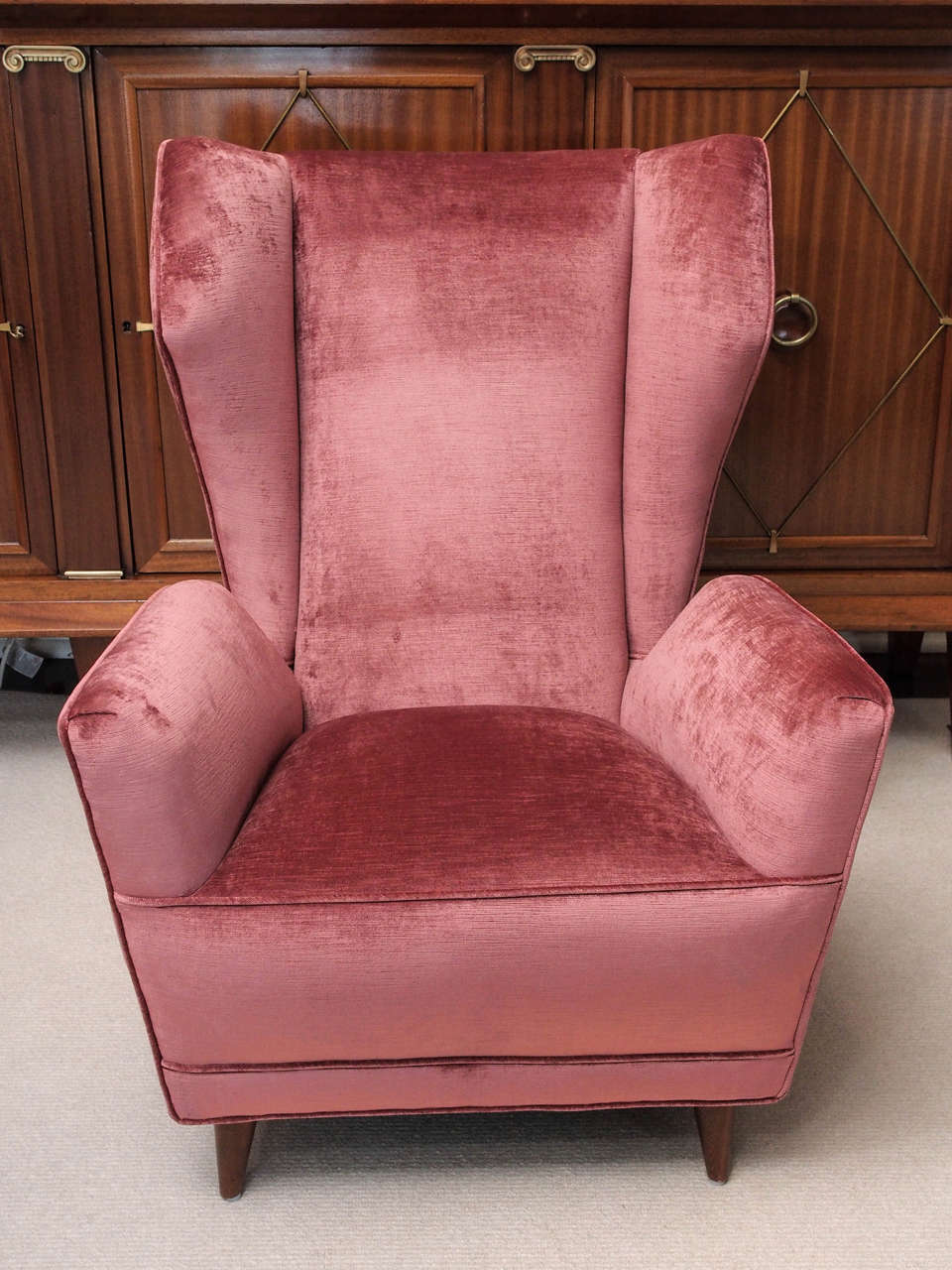 Pair of stylish Italian lounge chairs upholstered in rose pink velvet; the curving back of modified 