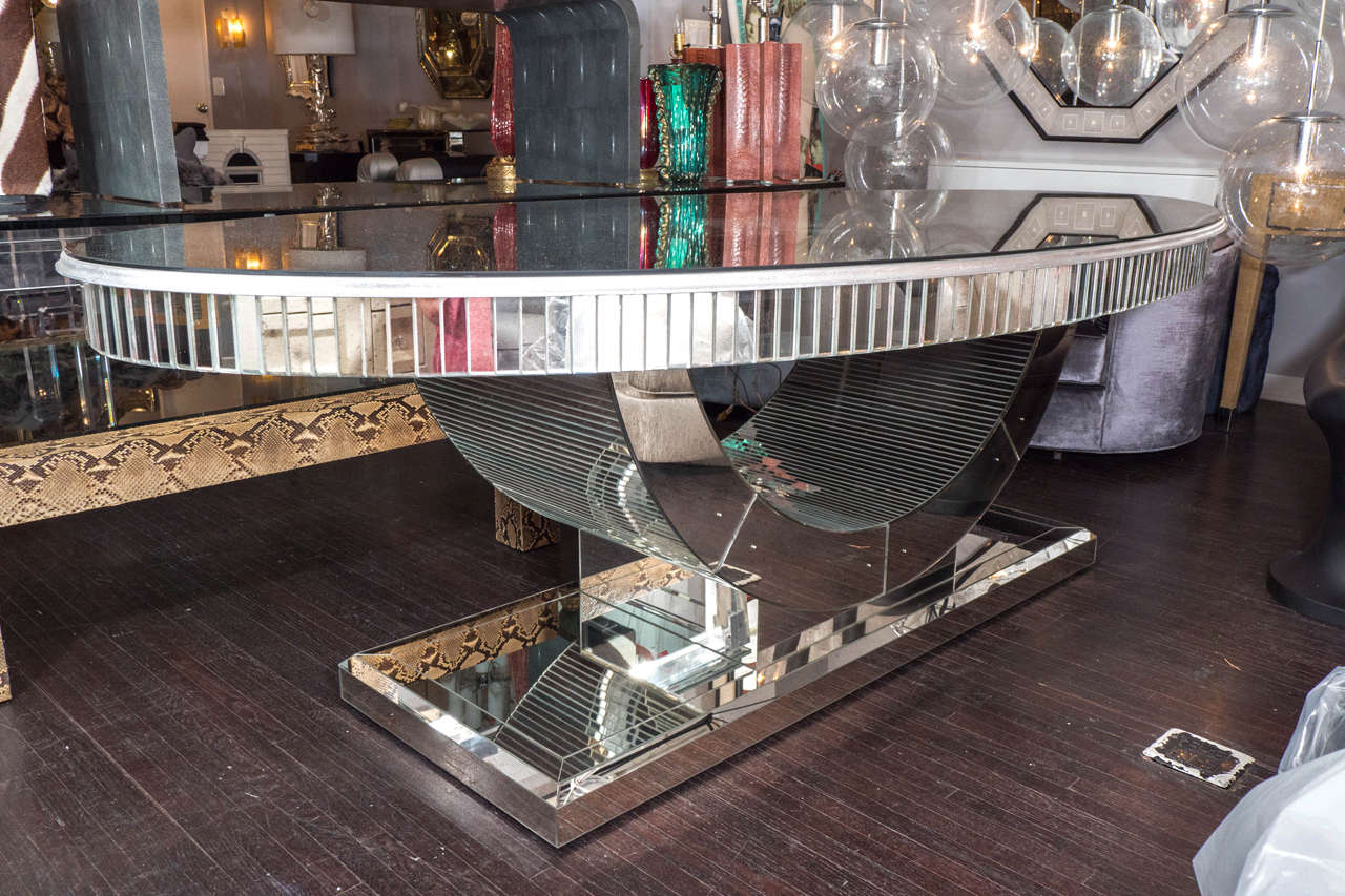 Beautiful silver leafed oval dining table with curved mirrored base.