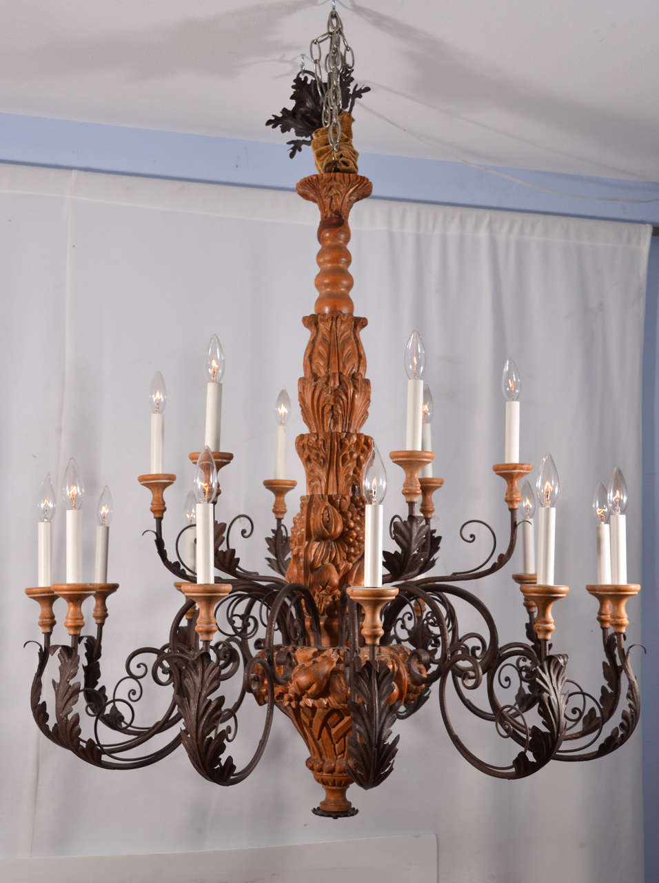 Country French, Hand Carved wooden fruit basket Chandelier.  Intricately fashioned fruit on the fiixture body with graceful scrolling arms adorned with acanthus leaves as the light unit,  Eighteen lights to enhance a large room.  The height of the